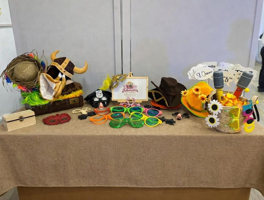 Mesa de atrezzo con gafas gigantes, sombreros, pelucas y carteles
