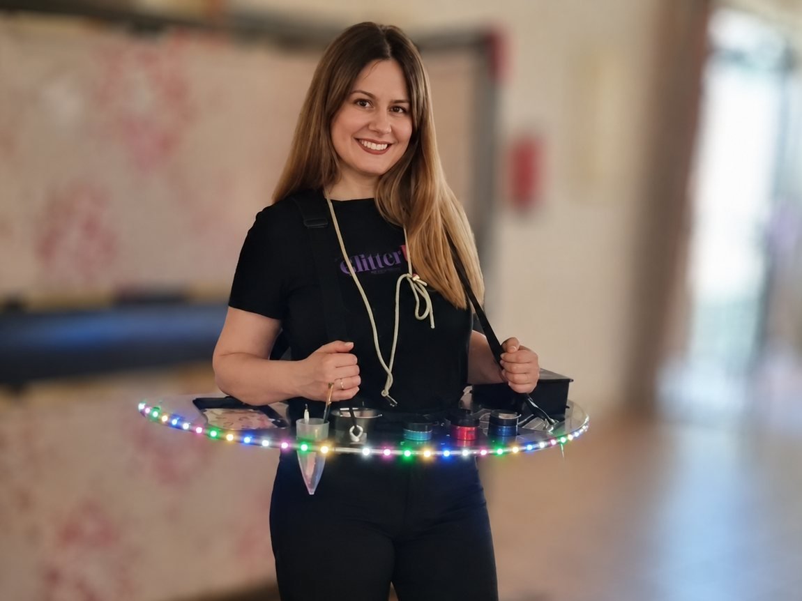 Cristina, de Fotomatón El Puerto, con la bandeja del glitter bar colgada e iluminada con luces LED, lista para recorrer el evento